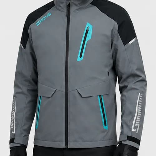 Chaqueta gris con cremallera central y cuello alto, paneles negros en los hombros, logotipo KOVE en verde agua en el pecho, bolsillo pectoral y bolsillos de cintura con cremallera verde agua, y una gráfica gris clara impresa en cada antebrazo; la lleva puesta un modelo con guantes y pantalón negros